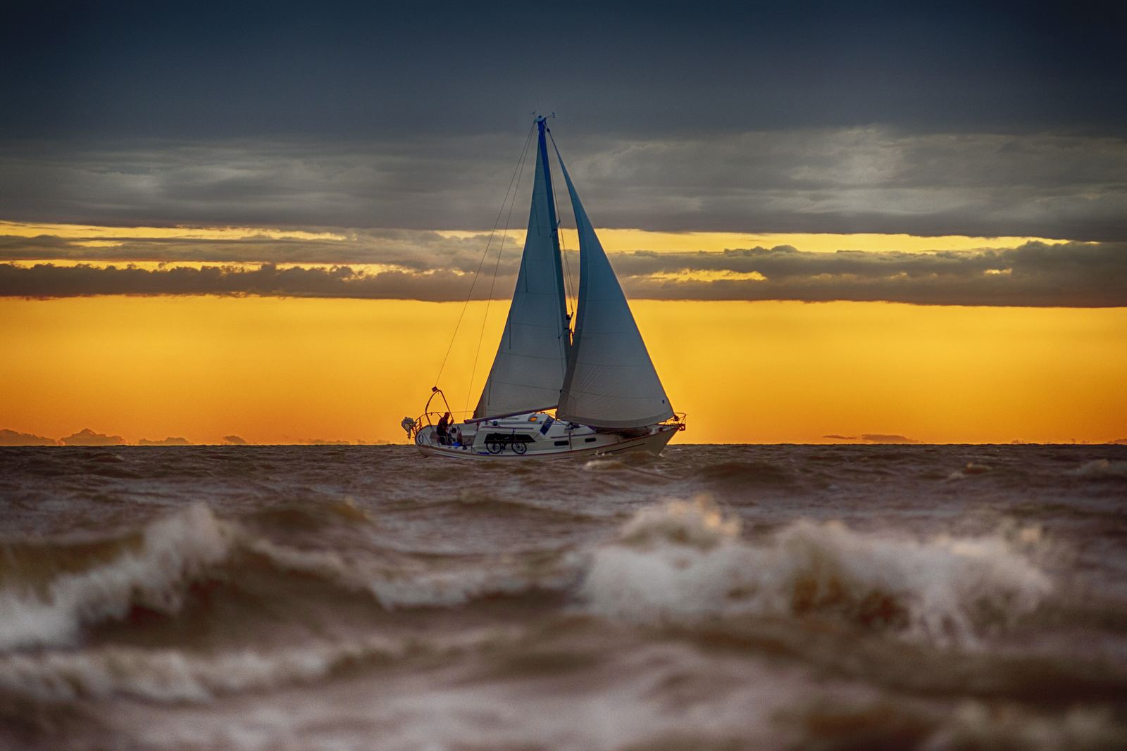 Velero navegando bajo un cielo dramático